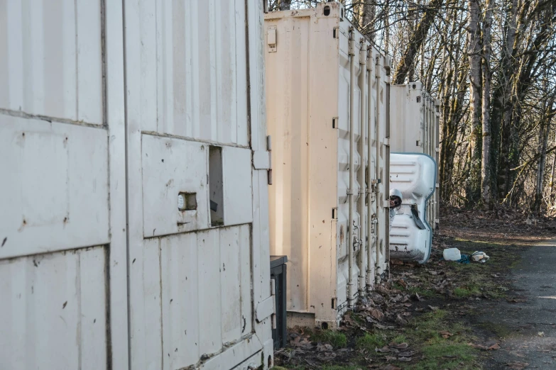 a set of two white barns with metal posts and doors