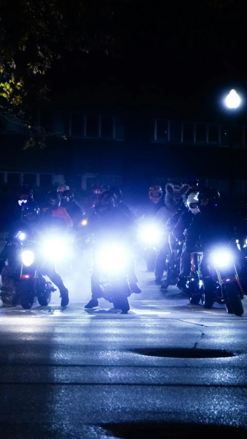police on motorcycles stand with their arms wrapped around their necks in a formation as it lights up