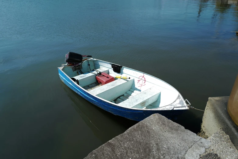 a blue and white rowboat tied to a dock