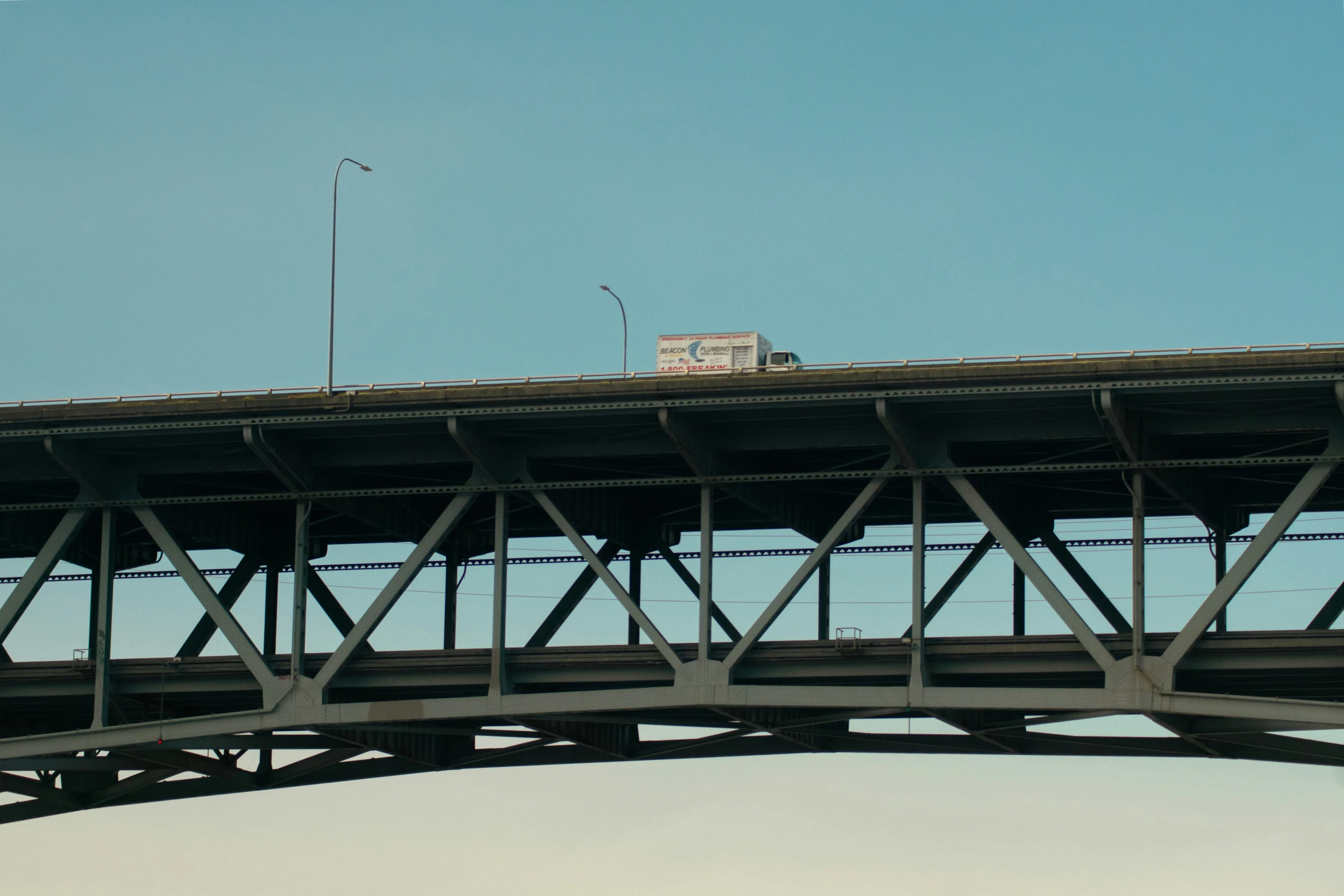 a bus traveling on the bridge with another bus below it