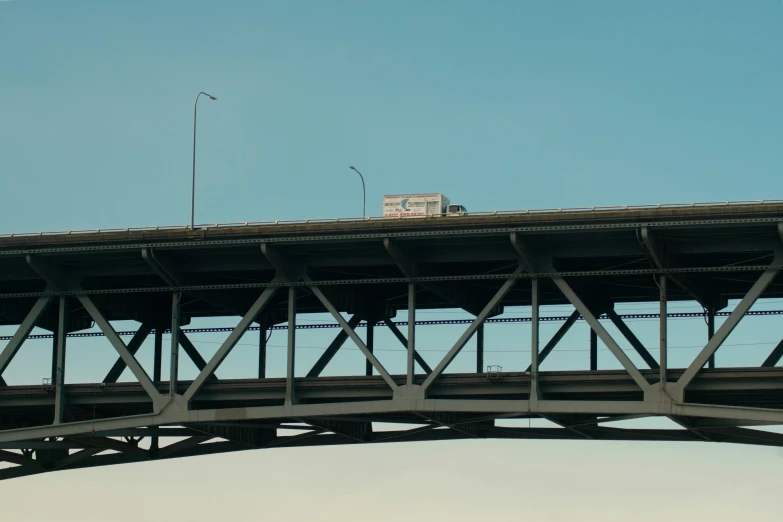 a bus traveling on the bridge with another bus below it