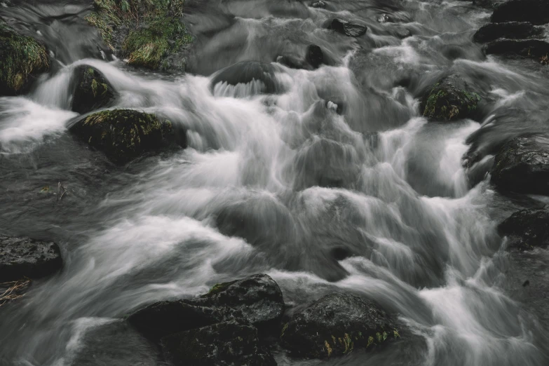a stream of water with rocks in the middle