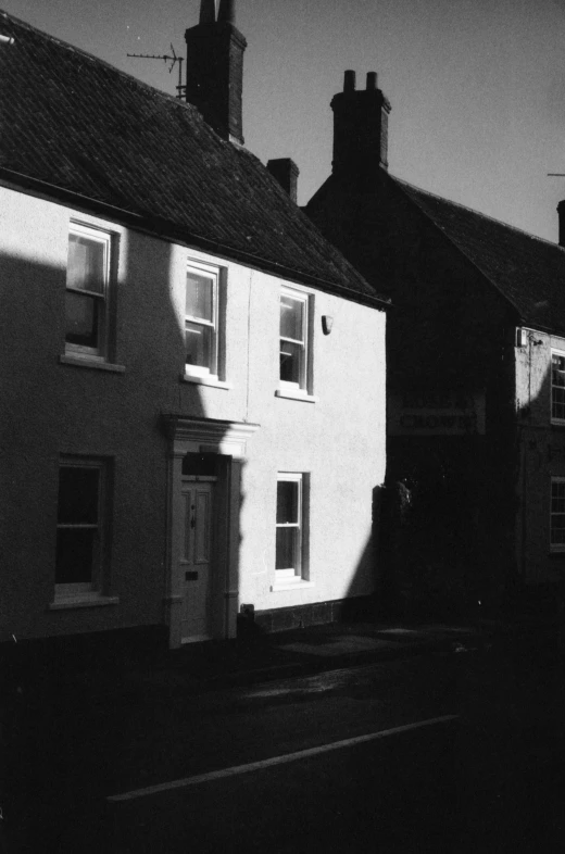 a black and white po of the sun shining in front of a row of houses