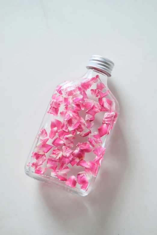 small pink flowers spilling out of a glass bottle