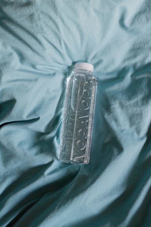 a bottle that is laying on a blue sheet