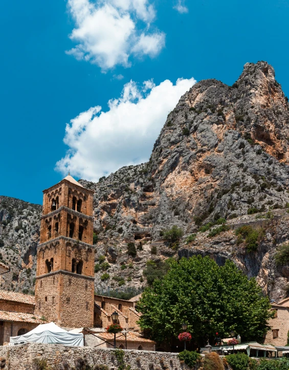 the large mountain is covered with rock and has a clock tower on top