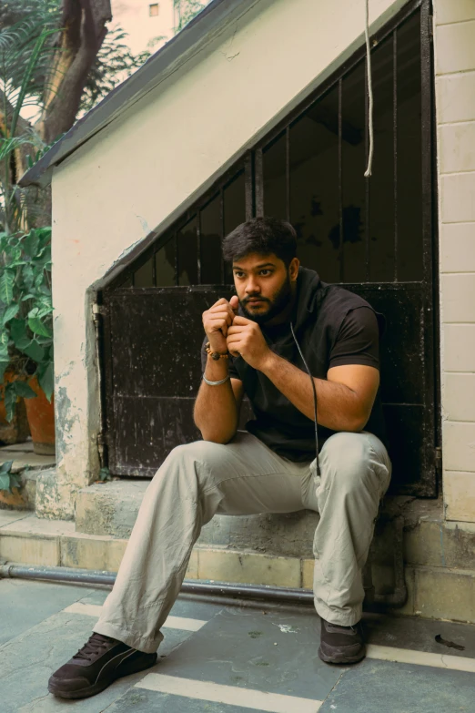 a man sits with his hands on his chest as he is looking up