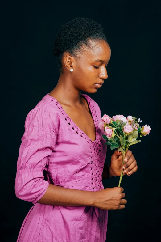 an african american woman holding a bouquet of roses