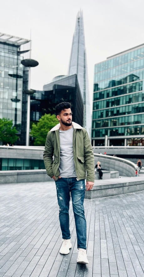 a man walking down the boardwalk near two buildings