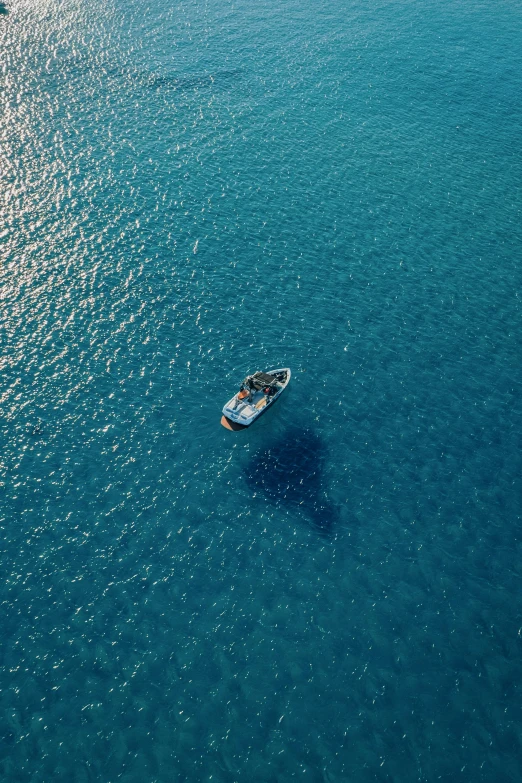 a small boat traveling through blue water