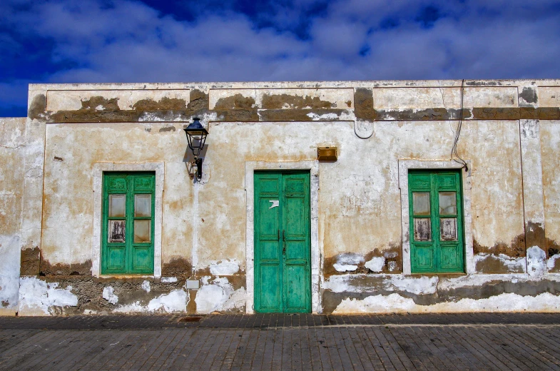 a green doored house sits on a cobblestone walkway