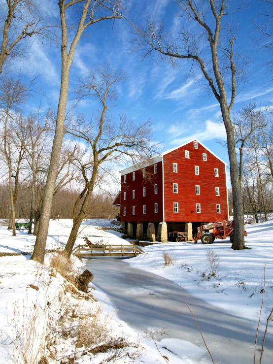 a red barn is in the middle of winter