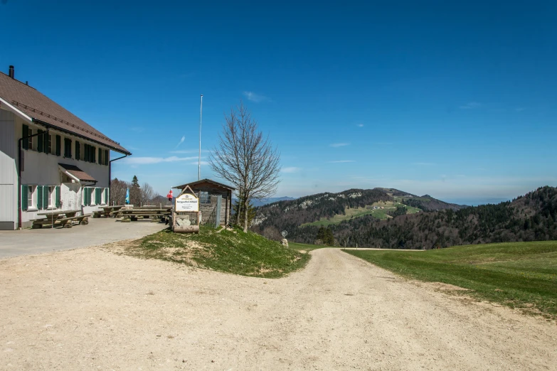 the view of the house on the dirt hill top from the parking lot