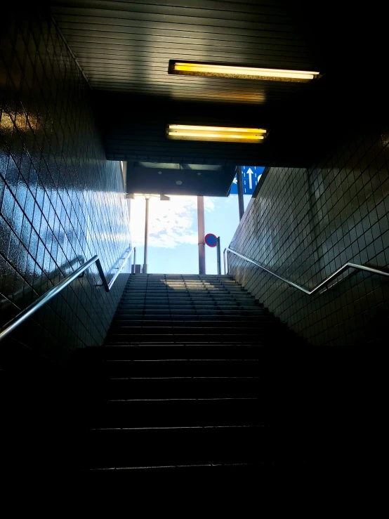 the stair way is dark with tiled walls