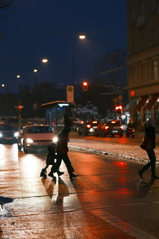 several people on a wet street at night with lights on