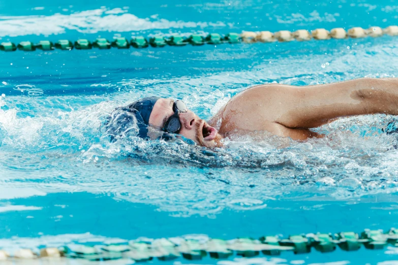 a man swims through the water on his back