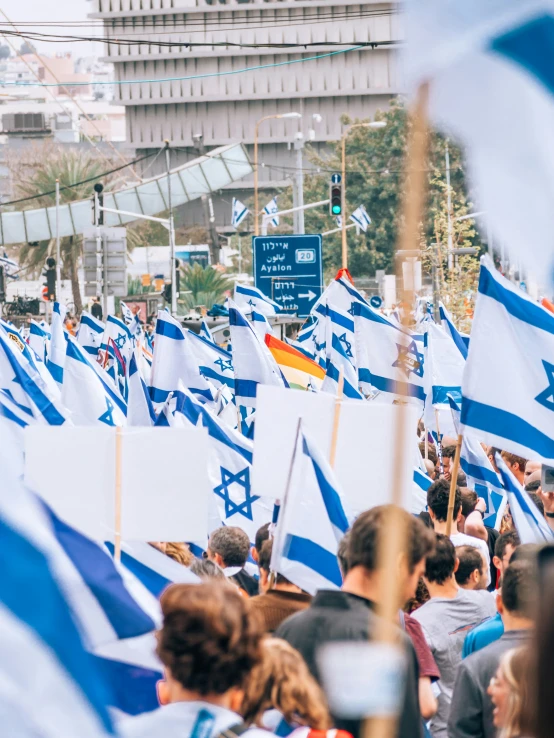 a large group of israeli flags with a man standing behind them