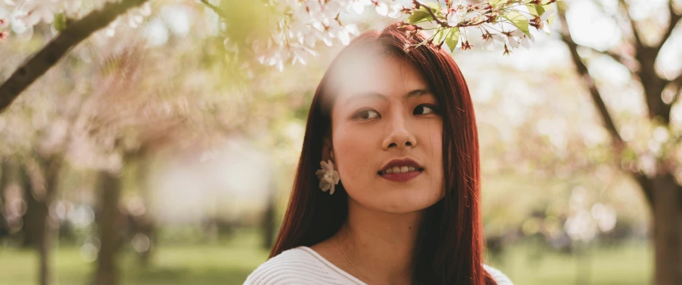 a woman looks at the camera through a tree