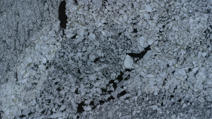 ice is piled on the ground and snow is falling