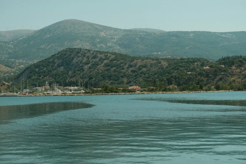 the mountains are covered in trees along the water