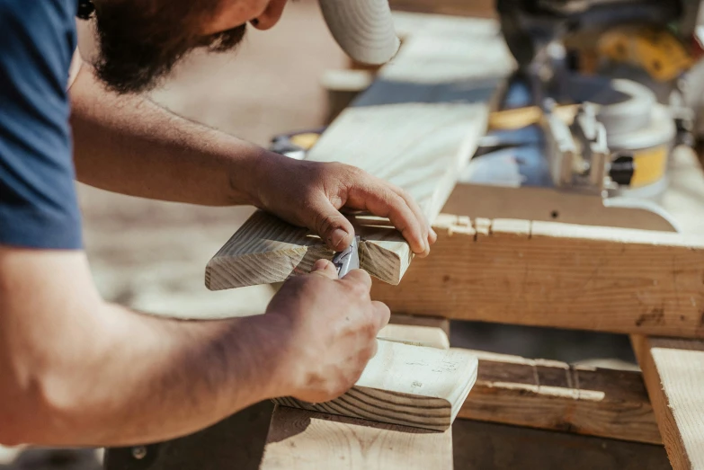 a person working on wooden object in a workshop