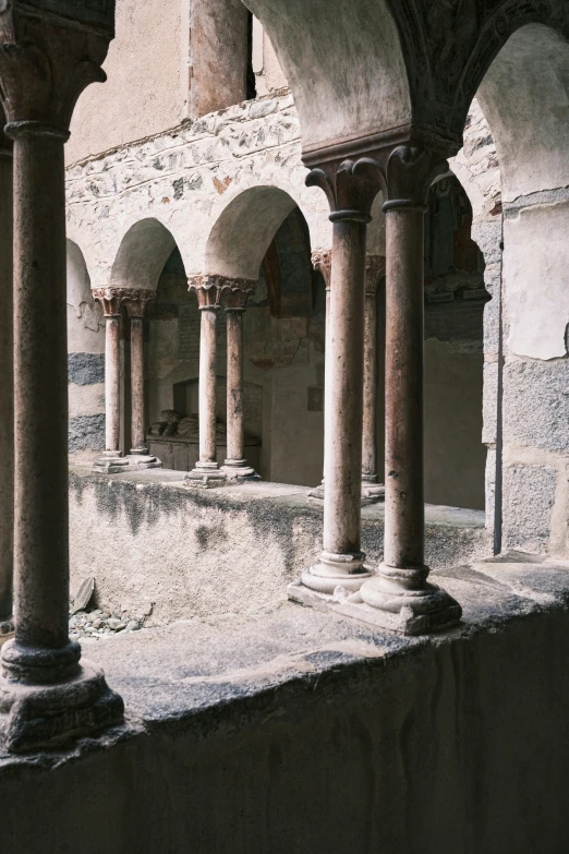 arches and pillars in an ancient building with stone floor