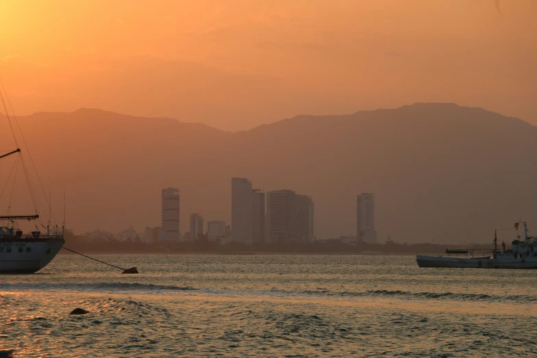 boats are on the water in front of a large city