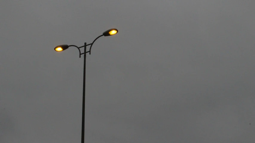 a long pole with two lights and two lamps on it