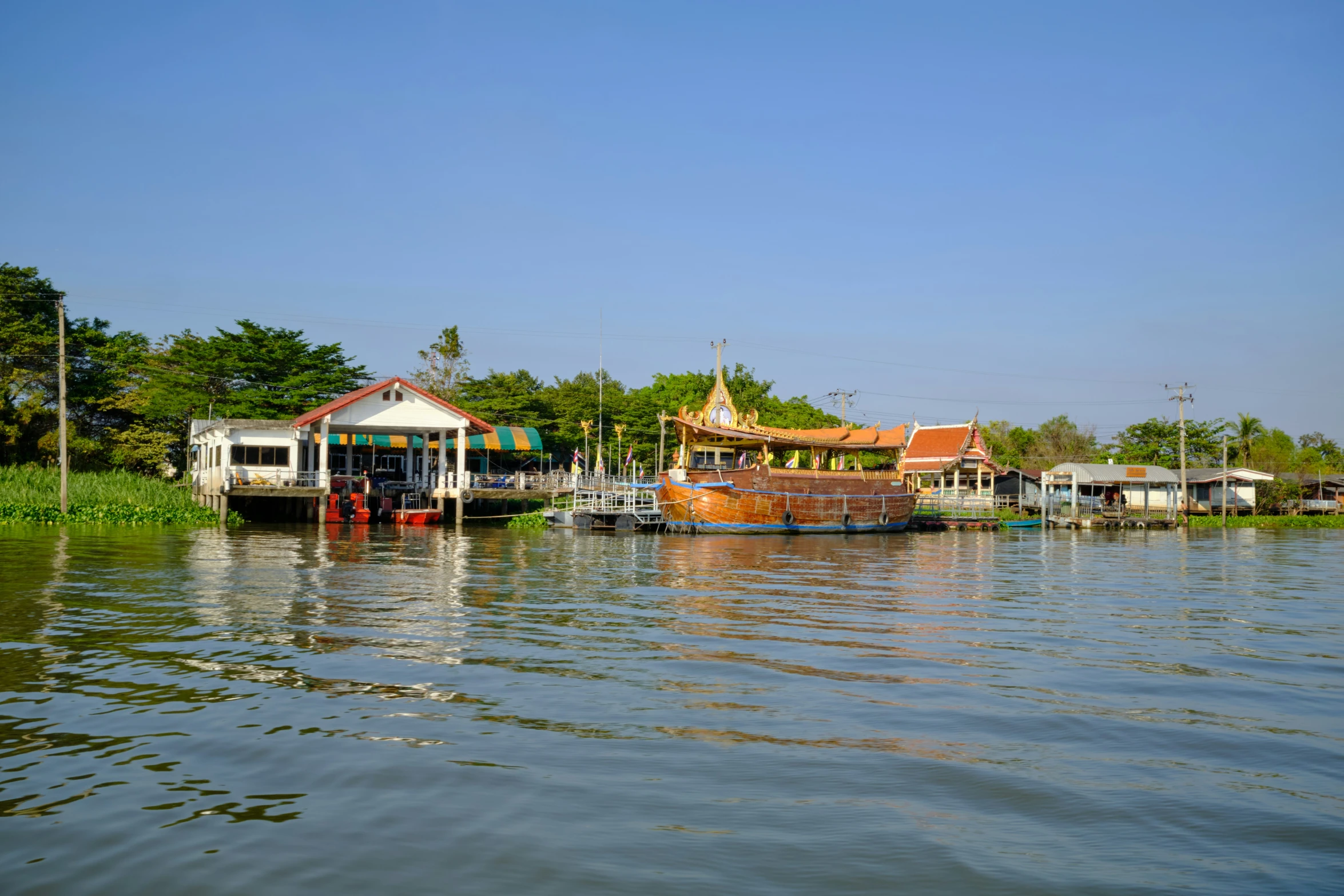 boats docked at a river with houses on the side