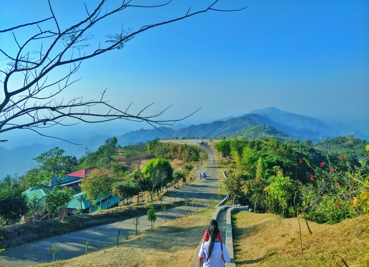 woman on trail looking at scenic view of hilly area