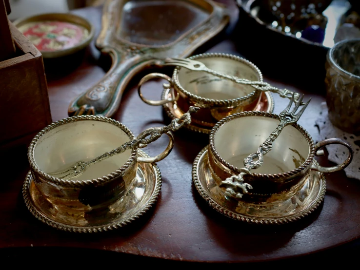 a few silver cups and plates on a table