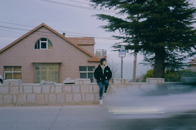 a man walks down the sidewalk past a large building