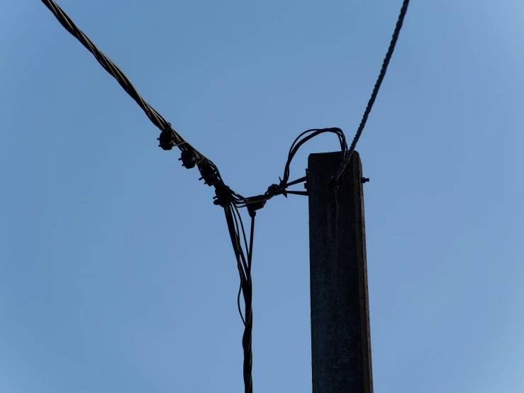 a telephone pole and power line against the blue sky