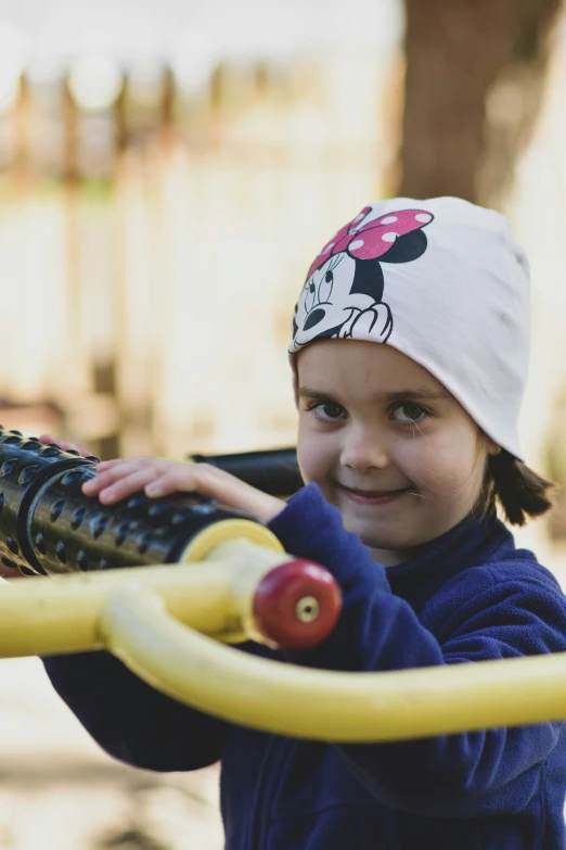 a little girl playing with a little yellow toy