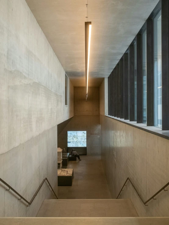 looking down a long concrete staircase in a building