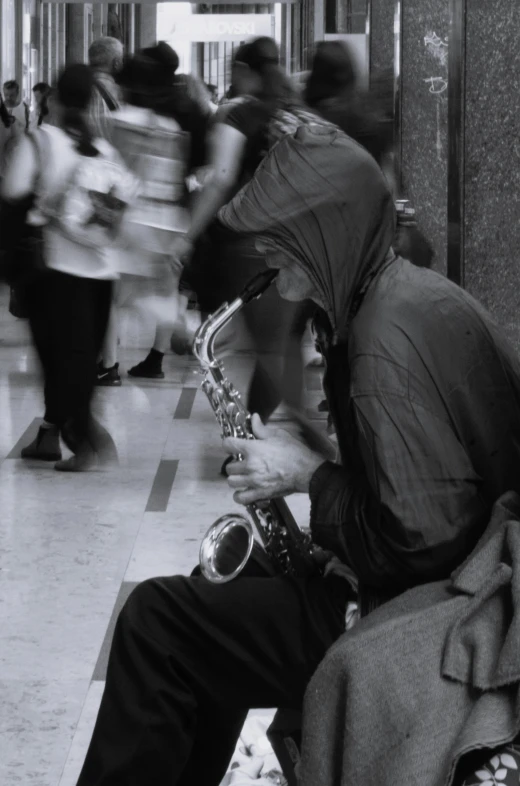 a man is sitting down while playing his saxophone