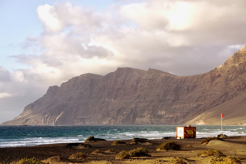 a mountain side with a beach and ocean