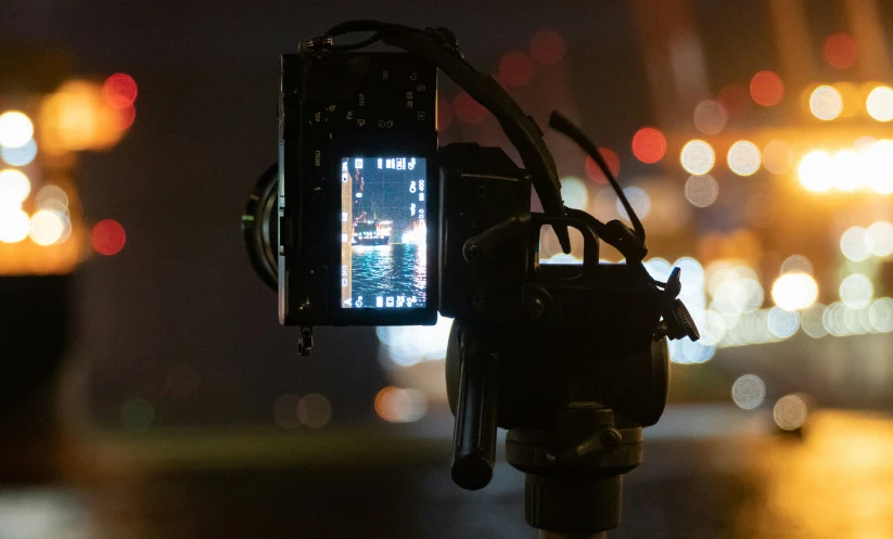 a street with buildings lights and a camera recording