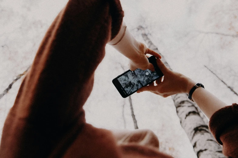 two people reaching for soing on their cell phone