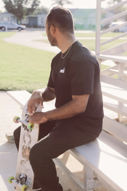 man sitting on ledge holding a skateboard