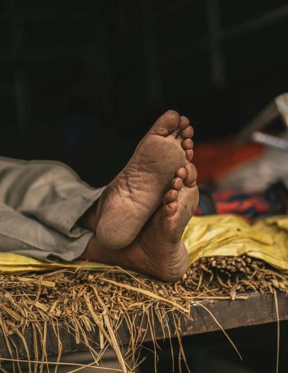 a person with big toe on top of an area covered in straw