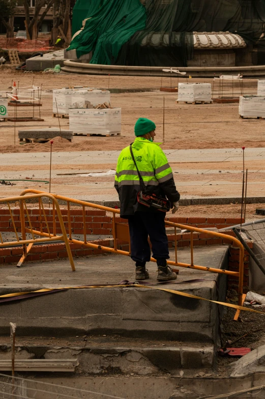 a person in safety clothing standing at the top of a construction site