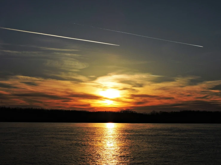 the sun reflecting off of the water as the airplane flies by