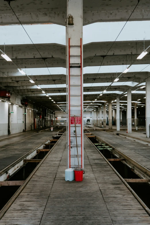 red ladder going up the ceiling in an old empty warehouse