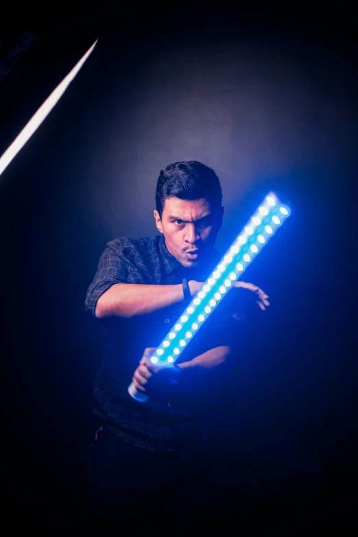 a man holding two led stick in front of his face