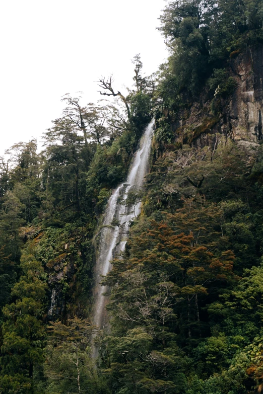 there is a tall waterfall coming down the mountain