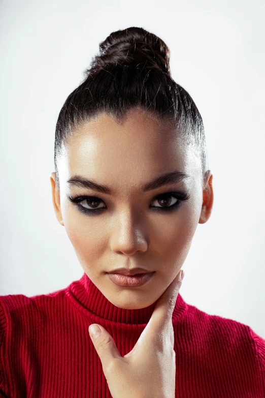 a beautiful young woman holding her hand to her temple