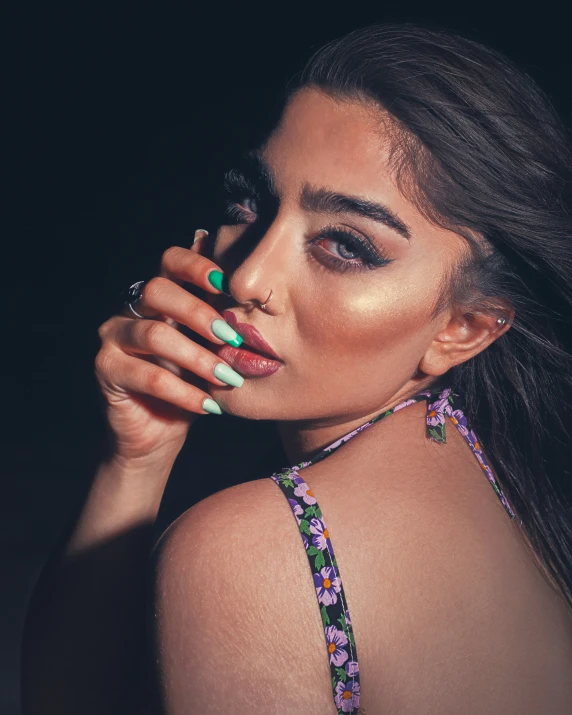 a woman with long, black hair and a ring on her finger posing for the camera