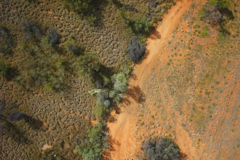 an overhead view of a jeep parked on a dirt road