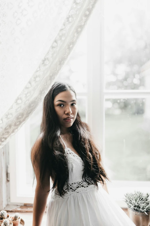 a young woman is posing for a po with her white dress